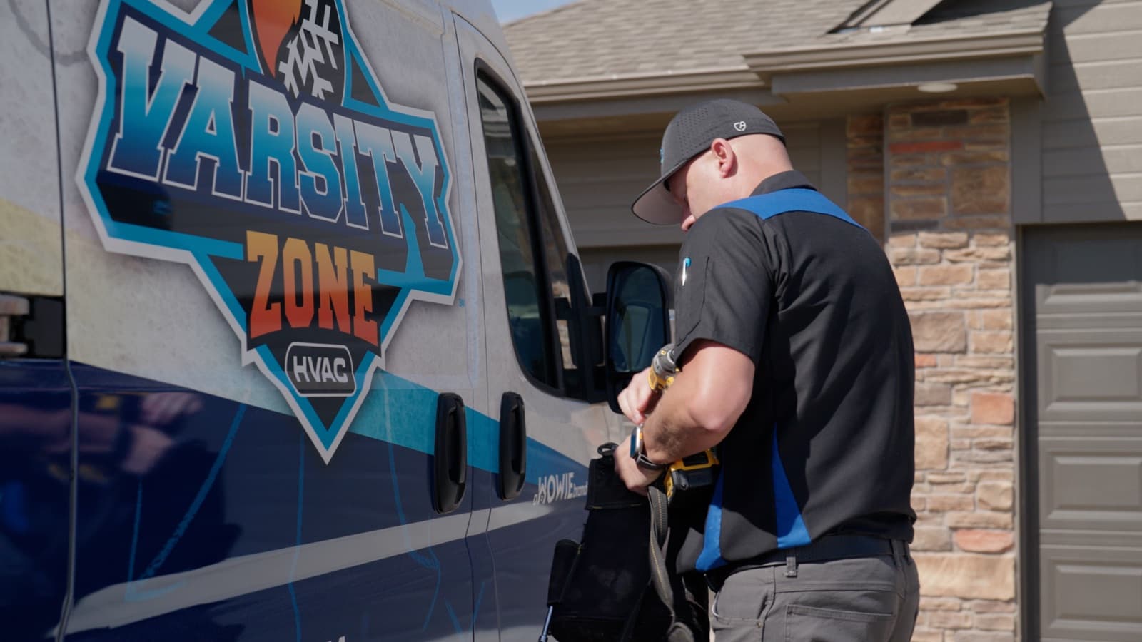 Varsity Zone HVAC technician beside a branded service van